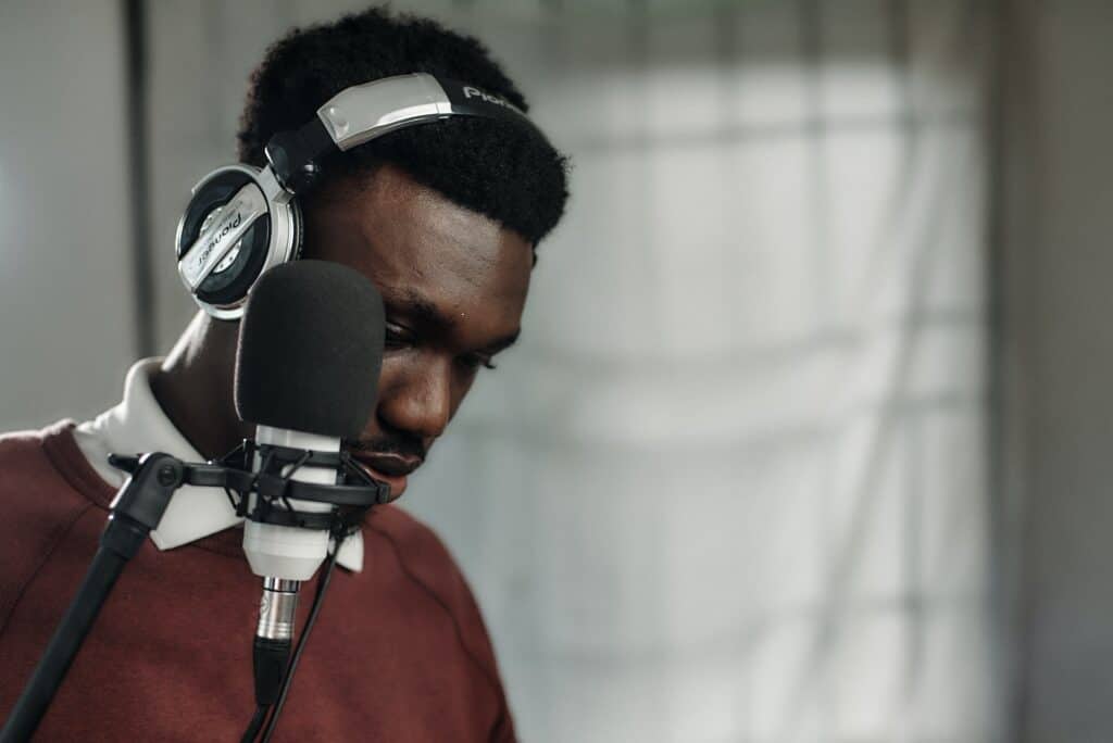 man wearing headphones recording himself on a microphone