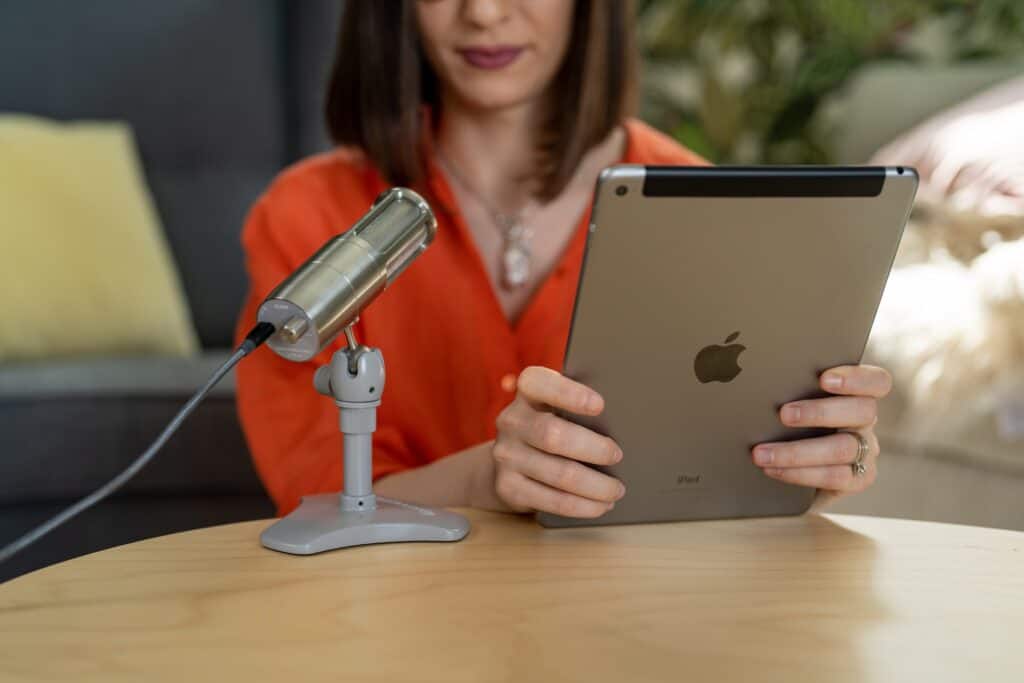 woman recording herself on a microphone with an iPad