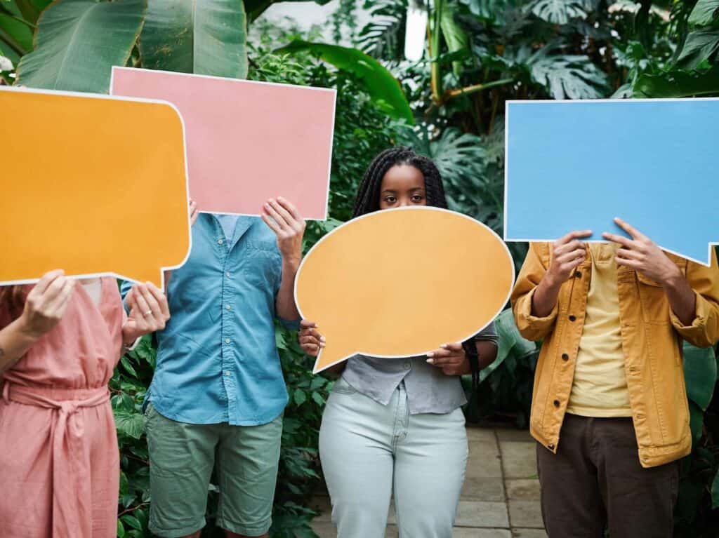 People holding up blank speech bubbles signs