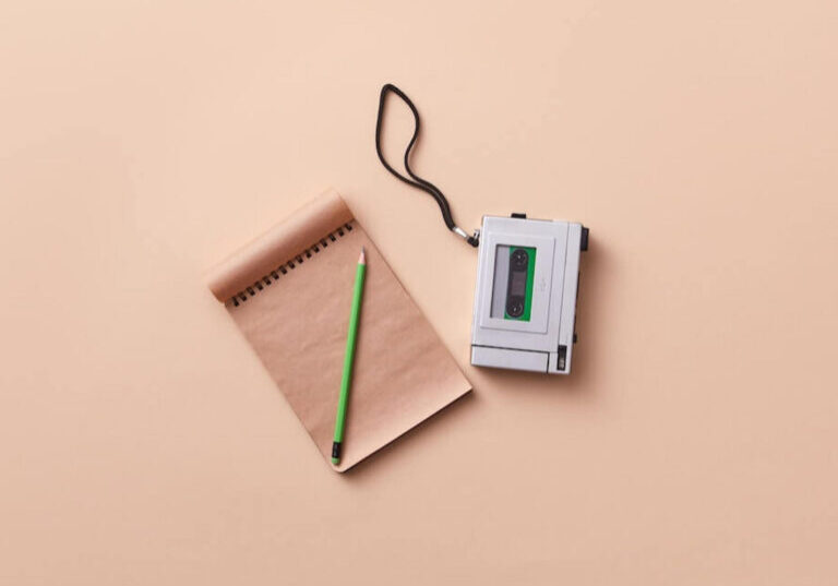 Voice recorder and a blank notebook with a pencil